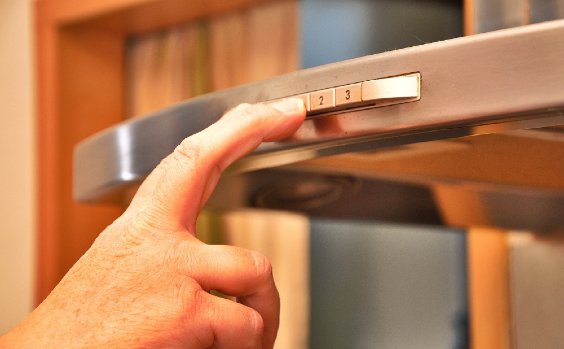 Finger auf Knopf von Dunstabzugshaube