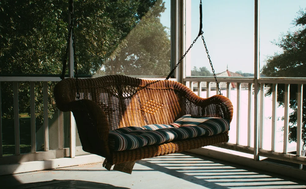 Hollywood-Schaukel auf einer weißen Veranda